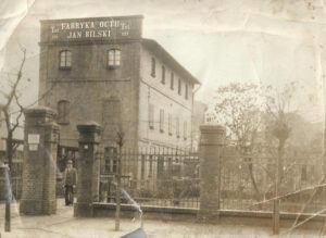 Fabryka Octu Jana Bilskiego (właściciel stoi po lewej za bramą), zdjęcie z początku lat 30. z archiwum rodzinnego pana Macieja Grzeszczaka