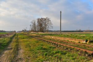 Przystanek Świątniki - widoczna krawędź dawnego peronu. Po lewej, w miejscu polnej drogi, miał znajdować się drugi tor. Zdjęcie 2021 rok.